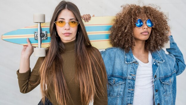 Meninas de tiro médio segurando o skate