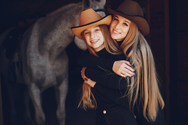 Meninas elegantes com um cavalo em uma fazenda