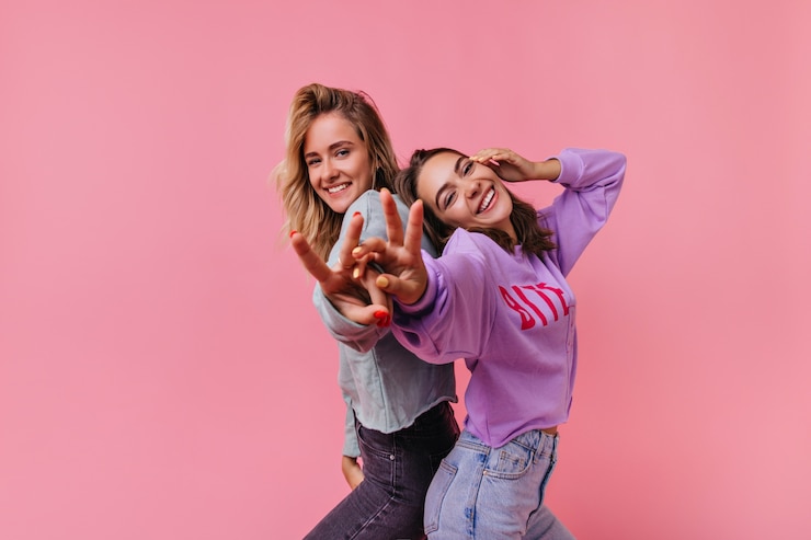 Foto grátis meninas emocionais fascinantes rindo e se divertindo. retrato de amigos alegres isolados na brilhante.