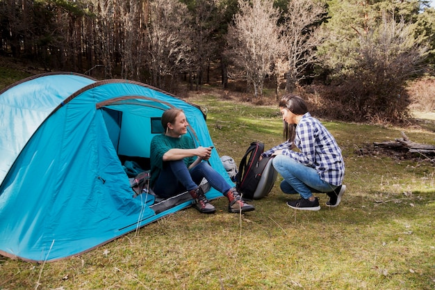 Meninas felizes com barraca no campo