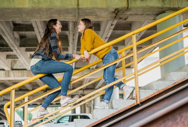 Meninas felizes da vista lateral que olham se