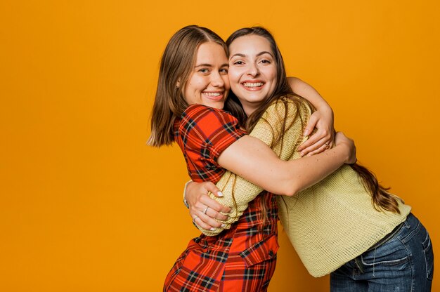 Meninas felizes de tiro médio abraçando