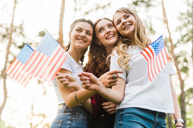 Meninas felizes na natureza com bandeiras americanas