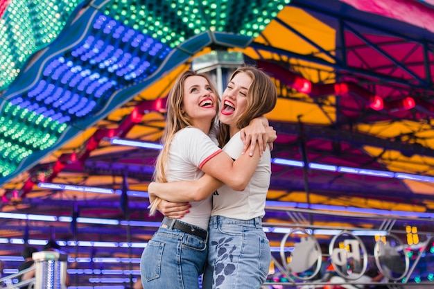 Meninas felizes se divertindo no parque de diversões