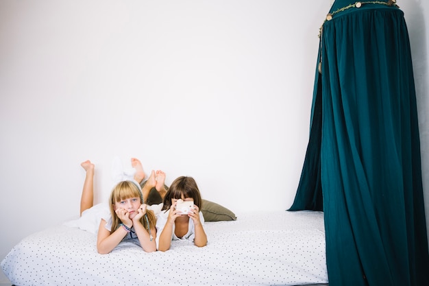 Meninas na cama com cortinas