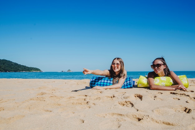 Foto grátis meninas na praia apontando