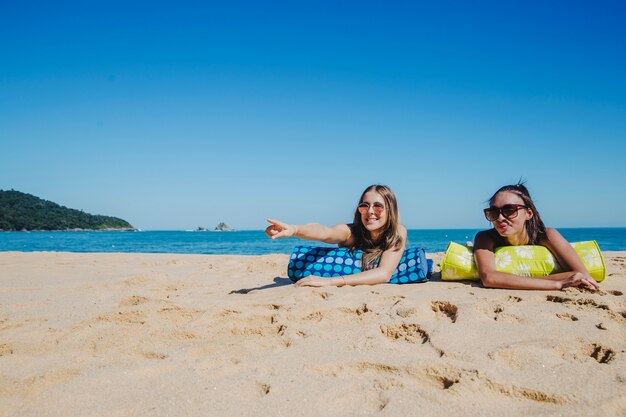 Meninas na praia apontando