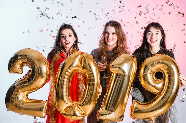 Foto grátis meninas posando com balão de ouro em uma festa de ano novo