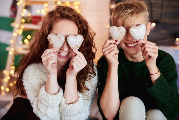Meninas segurando biscoitos de gengibre em forma de coração