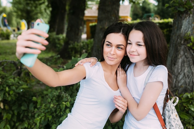 Meninas sorridentes abraçando tomando Selfie