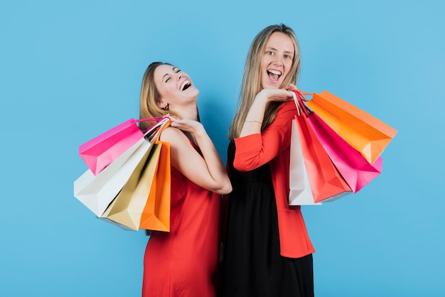 Meninas sorridentes, segurando sacolas de compras