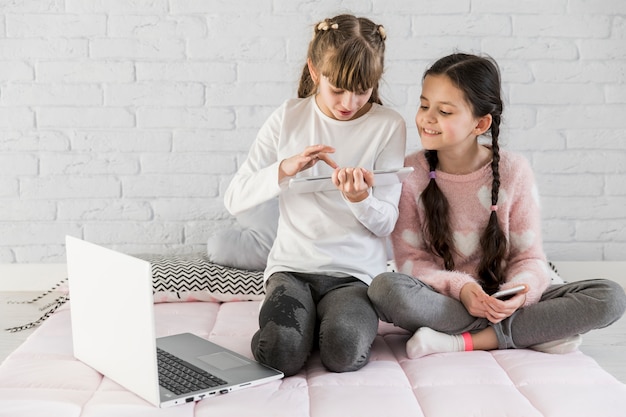 Meninas, usando computador portátil, junto