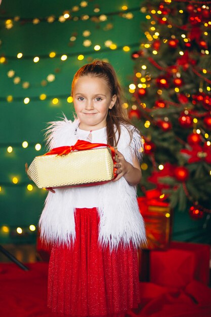 Menininha, desembrulhando, presente, por, árvore natal