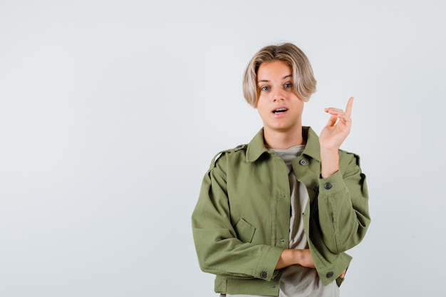 Menino adolescente apontando para cima em uma camiseta