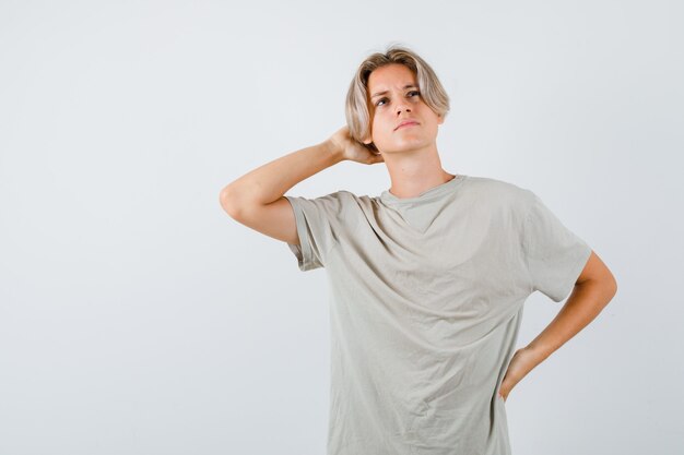 Menino adolescente com camiseta mantendo a mão atrás da cabeça