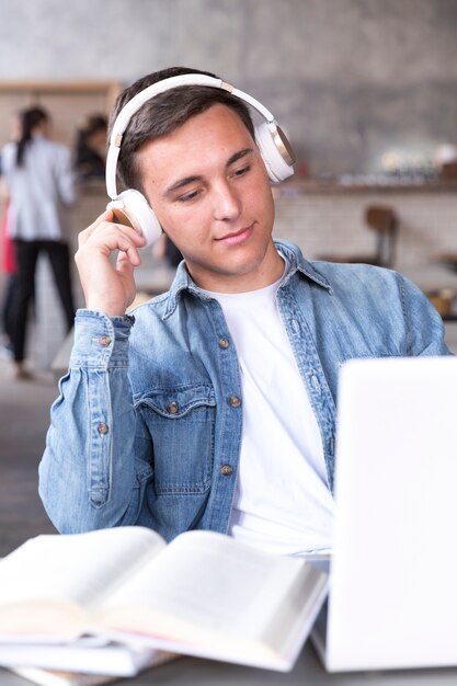 Menino adolescente, em, fones, sentando, tabela, em, sala aula