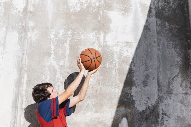 Menino adolescente, prática, basquetebol, frente, parede