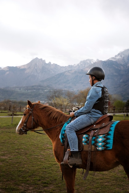 Foto grátis menino aprendendo a andar a cavalo