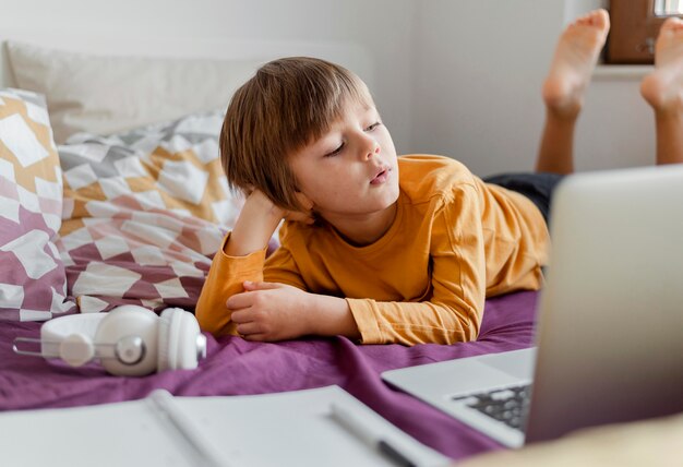 Menino aprendendo com suas aulas virtuais de laptop