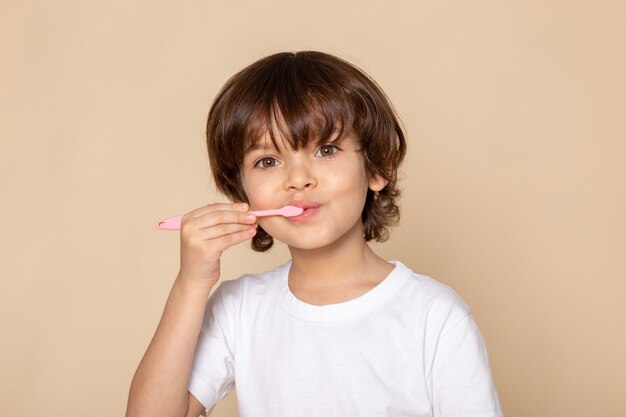 menino bonito adorável em t-shirt branca na rosa