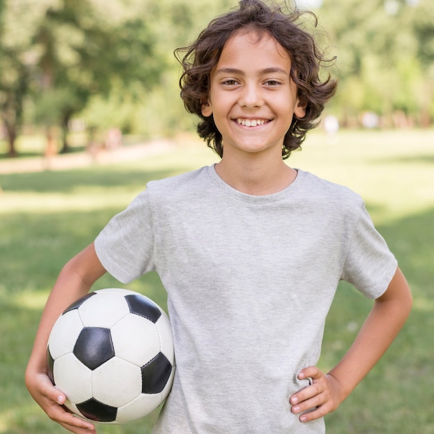 Menino brincando com bola de futebol