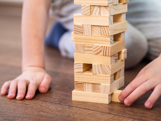 Menino brincando com o jogo da torre de madeira