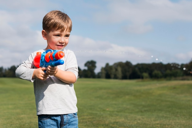 Menino brincando com uma pistola d'água