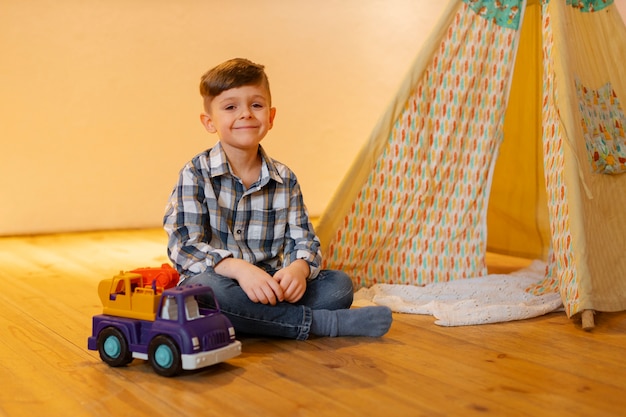 Foto grátis menino brincando dentro de casa com brinquedos ecológicos