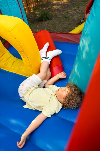 Menino brincando na casa de salto alto ângulo