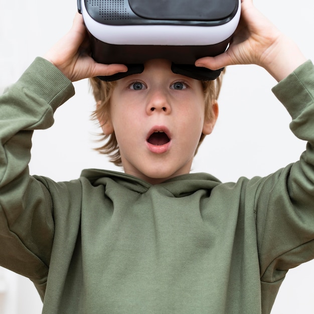 Menino chocado usando fone de ouvido de realidade virtual