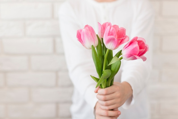 Menino close-up, segurando flores