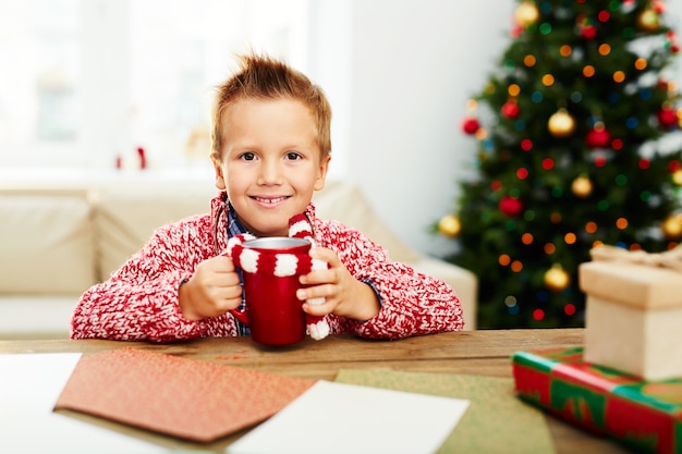 Menino com bebida no Natal