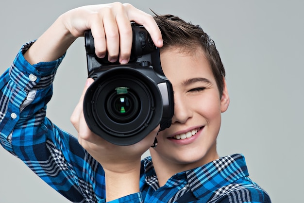 Menino com câmera fotográfica olhando pelo visor