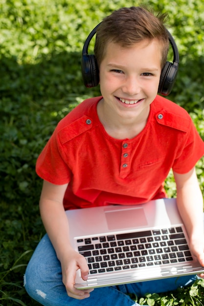 Menino com laptop e fones de ouvido