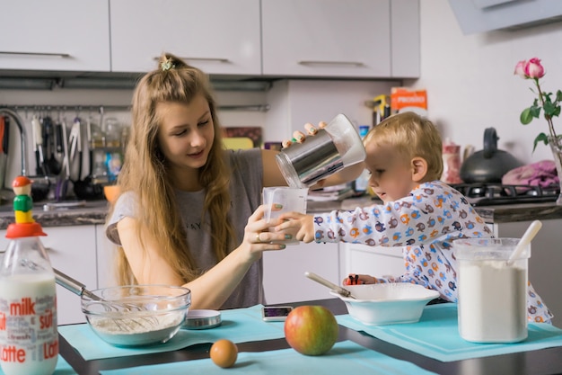 menino com mãe cozinhando na torta da cozinha