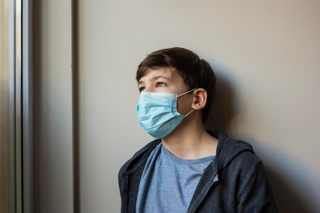 Foto grátis menino com máscara médica olhando para longe