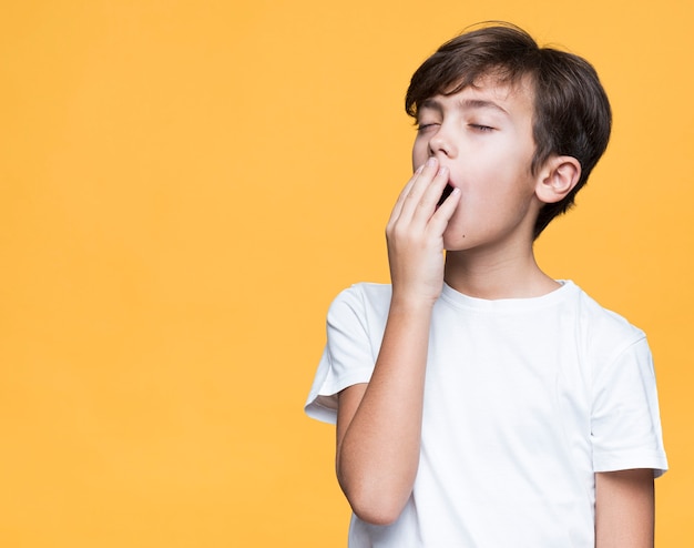 Menino com sono em fundo amarelo