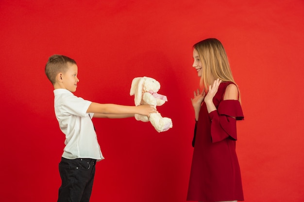 Menino dando pelúcia macia para uma menina