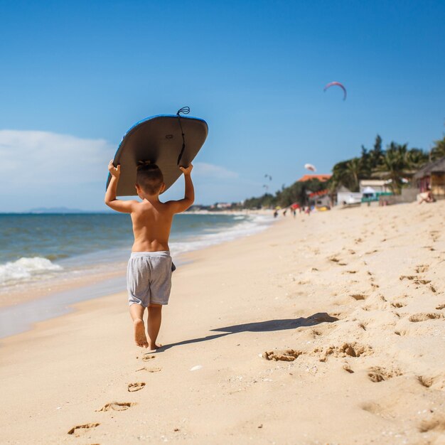 menino de 4 anos com uma prancha de surf