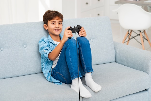Foto grátis menino de alto ângulo, brincando com joystick