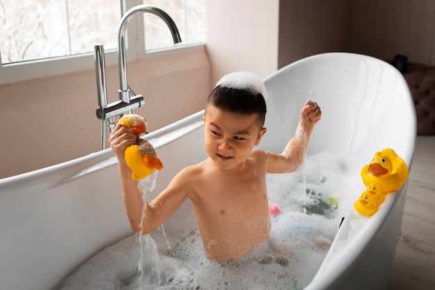 Foto grátis menino de alto ângulo brincando na banheira