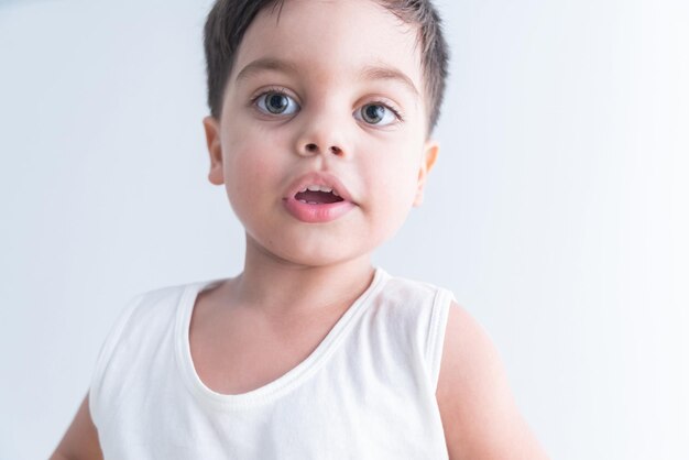 Menino de camiseta branca sobre fundo branco