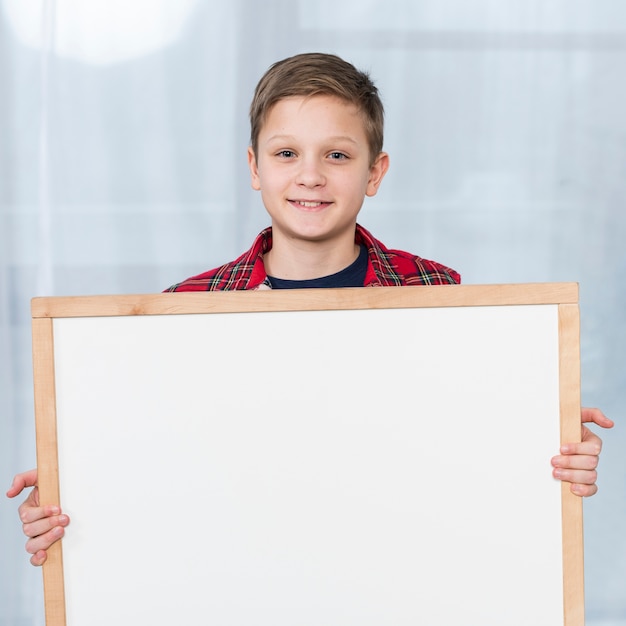 Foto grátis menino de retrato segurando o quadro