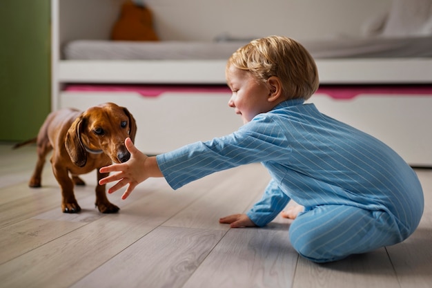 Foto grátis menino de tiro completo brincando com cachorro