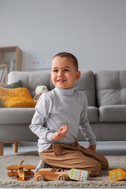 Foto grátis menino de tiro completo jogando em casa