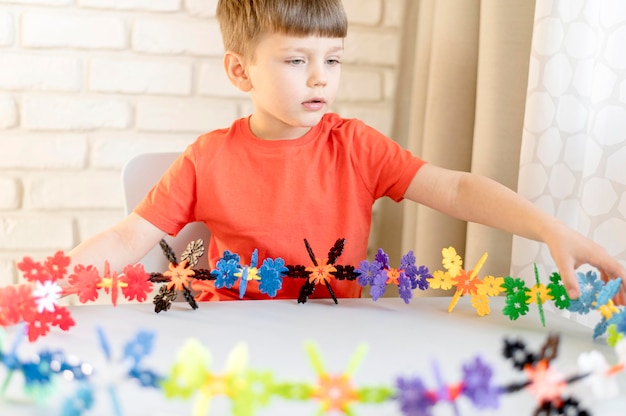 Foto grátis menino de tiro médio com brinquedo floral