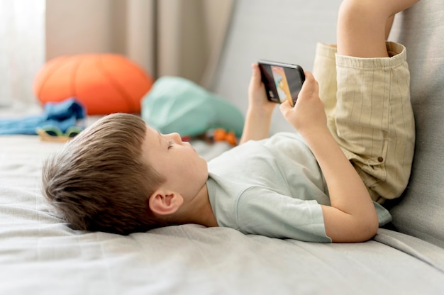 Menino de tiro médio com smartphone