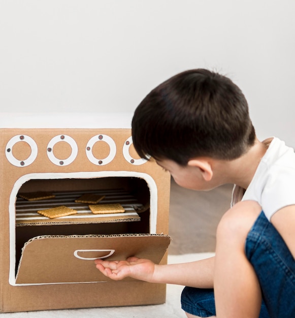 Menino de tiro médio, cozinhando em casa