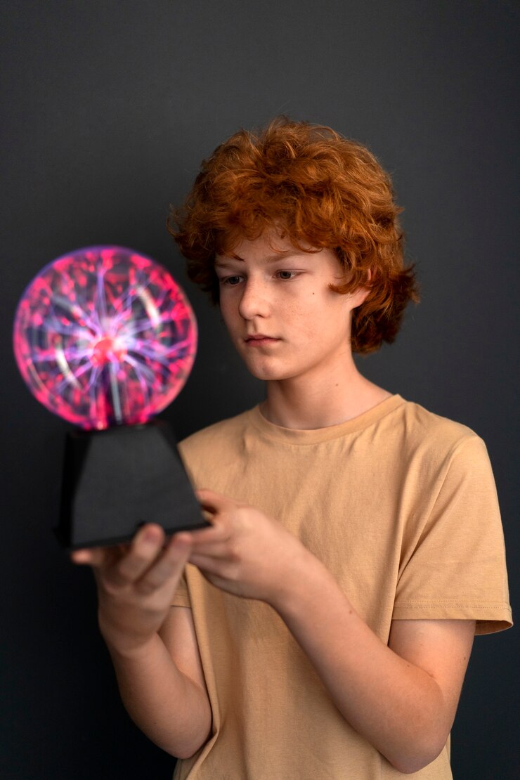 Foto grátis menino de tiro médio interagindo com uma bola de plasma