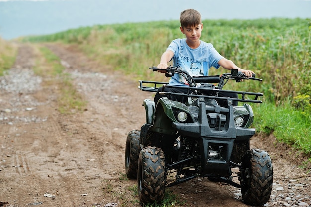 Foto grátis menino dirigir quadriciclo atv de quatro rodas